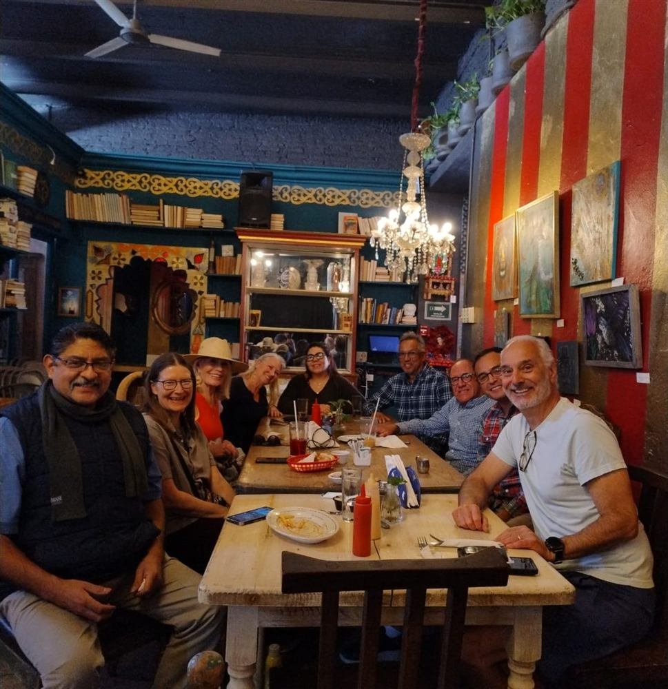 Integrantes del grupo Caregivers Unite reunidos alrededor de una mesa, sonriendo